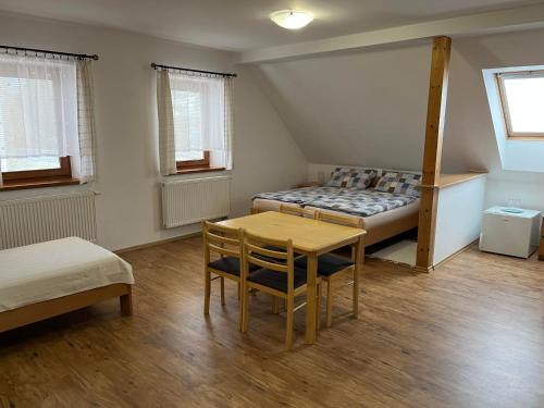 a bedroom with a bed and a table and chairs at Rožmberská Chalupa in Třeboň