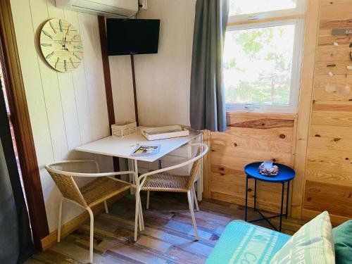 Cette petite chambre comprend une table, des chaises et une horloge. dans l'établissement Beach house à Marina di Sorbo …Corse, à Sorbo-Ocagnano