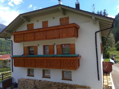 a white house with wooden balconies on it at Ferienwohnung für 8 Personen ca 95 qm in Pellizzano, Trentino Val di Sole in Pellizzano