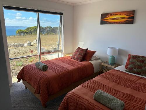 a bedroom with two beds and a large window at Ocean Yakka, Kangaroo Island in Penneshaw