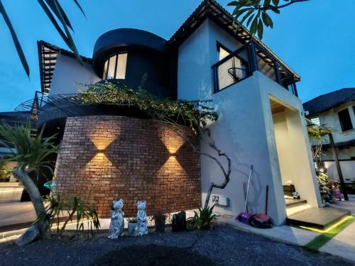 deux chats assis devant une maison dans l'établissement D'Cove Villa Private Pool Kuantan, à Kuantan
