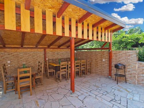 a wooden pergola on a patio with a table and chairs at Ferienwohnung für 4 Personen ca 40 qm in Fažana-Surida, Istrien Istrische Riviera - b54424 in Valbandon