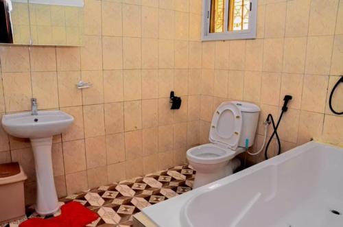 a bathroom with a toilet and a sink at Sunu Sal Apartment in Kololi