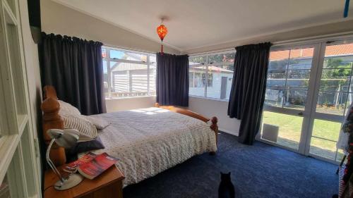 a bedroom with a bed and a cat in it at 135 On Seaview Parpaparaumu Beach in Paraparaumu