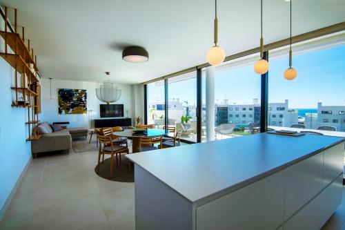 a kitchen and living room with a large window at Mara's Apartments Higuerón West - Luxurious & Sunny in Fuengirola