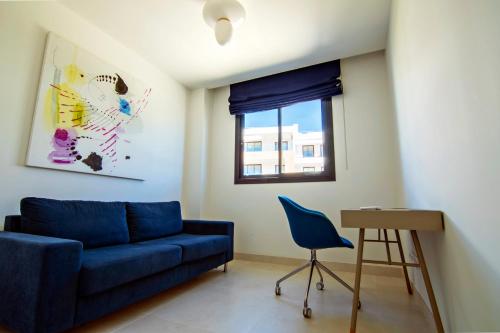 a living room with a blue couch and a chair at Mara's Apartments Higuerón West - Luxurious & Sunny in Fuengirola