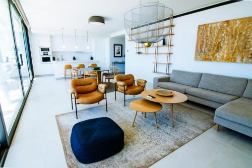 a living room with a couch and a table and chairs at Mara's Apartments Higuerón West - Luxurious & Sunny in Fuengirola