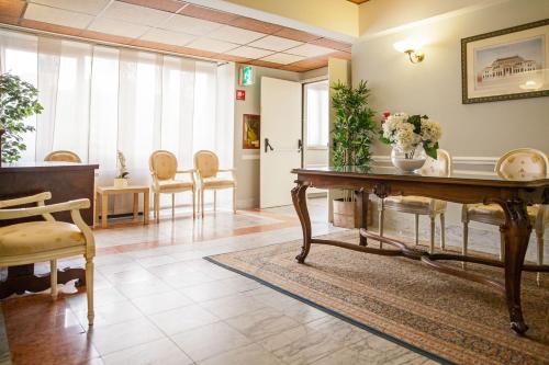 a waiting room with a table with flowers on it at Hotel Concord in Turin