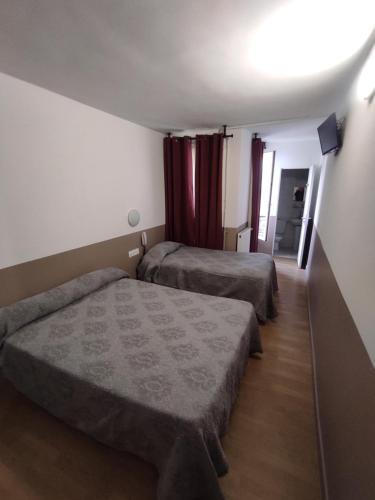 um quarto de hotel com duas camas e uma janela em Hotel de Nantes em Paris