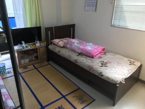a small bedroom with a bed and a night stand at Hanmadang in Osaka