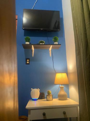 un tavolo con una lampada e una TV su una parete blu di Volcano Pines Retreat ad Alto Boquete