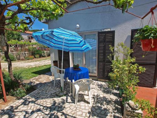 een tafel en twee stoelen met een blauwe tafel en een paraplu bij Ferienwohnung für 3 Personen ca 27 qm in Pula, Istrien Istrische Riviera in Pula