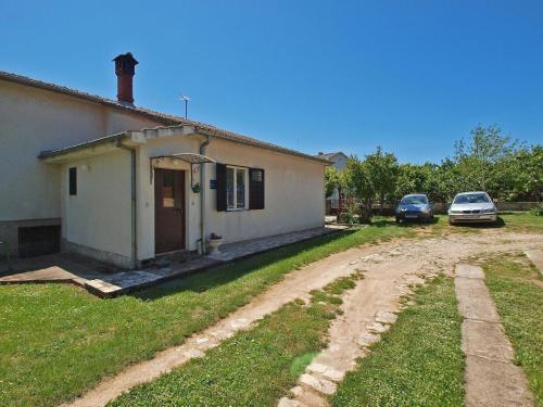 een huis met twee auto's geparkeerd naast een onverharde weg bij Ferienwohnung für 3 Personen ca 27 qm in Pula, Istrien Istrische Riviera in Pula
