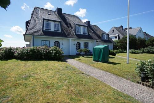 una casa bianca con tetto nero di Ferienwohnung für 4 Personen ca 111 qm in Munkmarsch, Nordfriesische Inseln Sylt a Munkmarsch