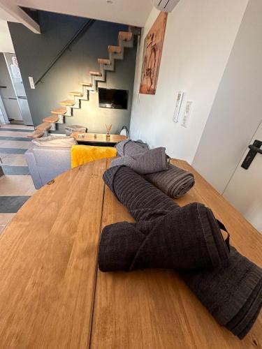 - une grande table en bois dans une chambre avec des escaliers dans l'établissement Le Petit Valexiane Piscine & Jardin, à Maillane