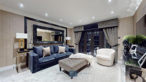 a living room with a blue couch and a chair at Grand London suburban mansion in Buckhurst Hill