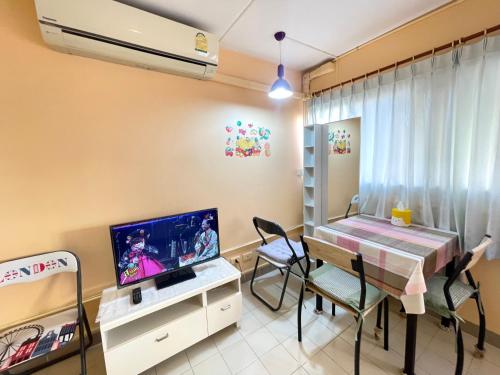a room with a desk and a tv and a table and chairs at Lively Impact C3-C9 in Nonthaburi