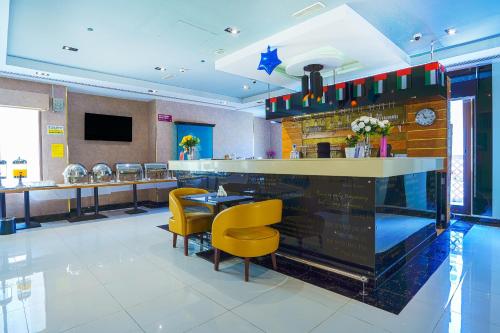a restaurant with yellow chairs and a bar at Palette Royal Reflections Hotel and Spa Dubai in Dubai