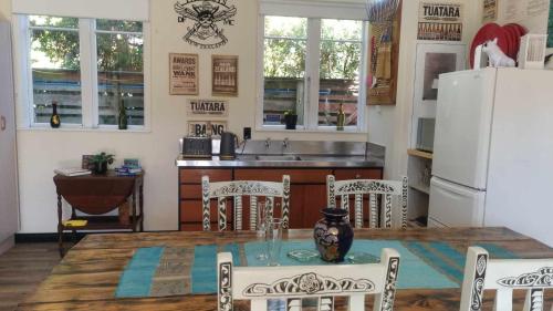 帕拉帕拉乌穆135 On Seaview Parpaparaumu Beach的配有桌椅和冰箱的厨房