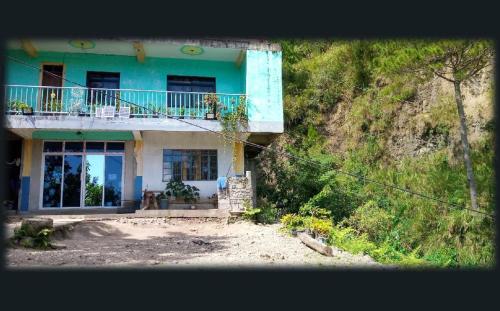una casa azul y blanca al lado de una colina en An Escape to a Semi-Countryside Retreat - SEE TOO VILLE- Nature Lodging Home, en Sagada