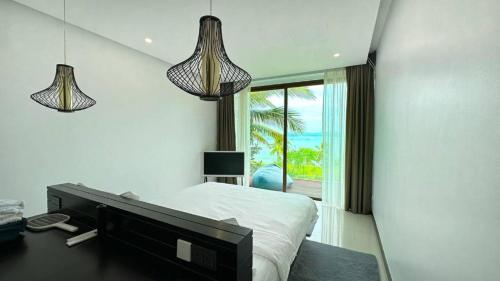 1 dormitorio con 1 cama, 2 luces y ventana en Sunrise ocean villa, en Phuket