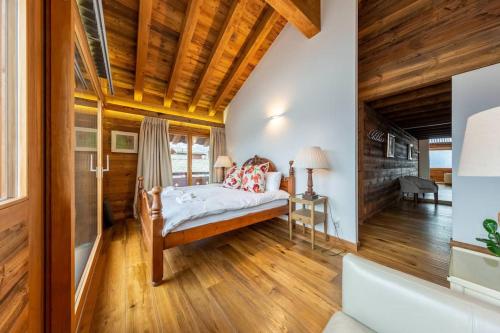a bedroom with a bed and a wooden ceiling at Penthouse spa access , 6 bedroom, 6 baths by Jolidi in Nendaz