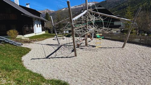 a playground in a yard next to a house at MountainView Lodge - Am Fuße der Gondel und Skipiste in Sankt Oswald