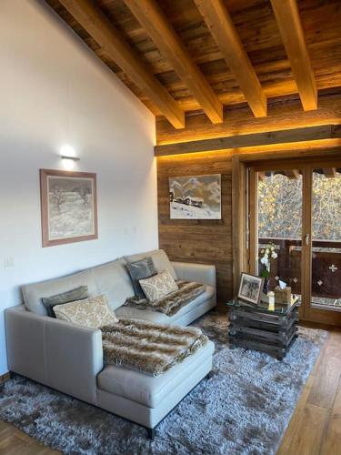 a living room with a couch and a table at Penthouse spa access , 6 bedroom, 6 baths by Jolidi in Nendaz