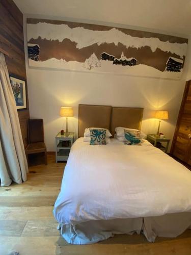 a bedroom with a large white bed with two pillows at Penthouse spa access , 6 bedroom, 6 baths by Jolidi in Nendaz