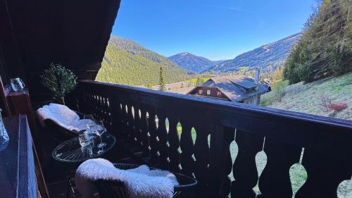 een balkon met 2 stoelen en uitzicht op de bergen bij MountainView Lodge - Am Fuße der Gondel und Skipiste in Sankt Oswald