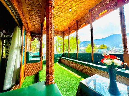 einem Zugwagen mit grünen Sitzen und einer Vase voller Blumen in der Unterkunft Floating Luxury Group Of Houseboats in Srinagar