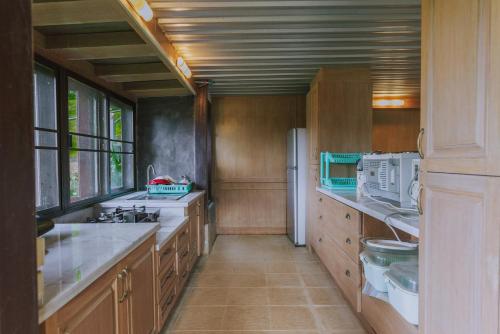 a large kitchen with wooden cabinets and a refrigerator at Muangkham Cabin in Chiang Mai