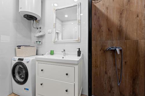 a bathroom with a sink and a washing machine at Old Tower Center Apartment in Pula