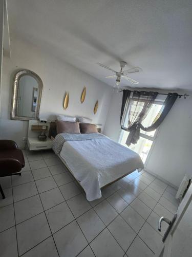 マルセイユにあるJoli appartementのベッドと鏡のある白い寝室