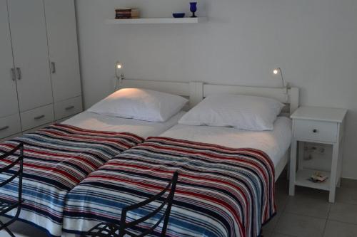 ein Schlafzimmer mit einem Bett mit gestreifter Decke in der Unterkunft Studio für 5 Personen ca 60 qm in Tribunj, Dalmatien Norddalmatien in Tribunj