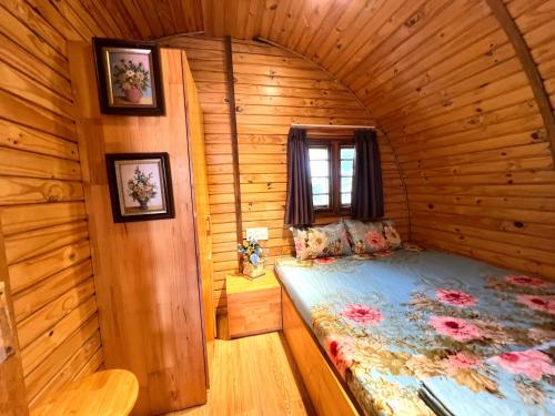 a bedroom with a bed in a wooden room at BUNGALOW DANANG Healing Homestay 