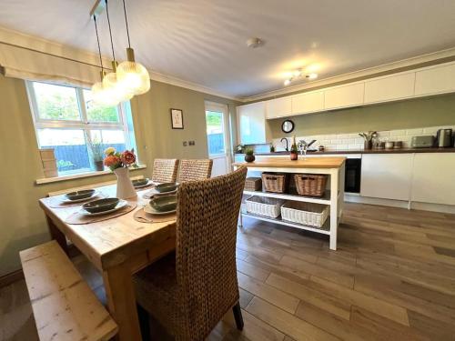 a kitchen and dining room with a wooden table and chairs at Olive Holiday Cottage Matlock in Matlock Bank