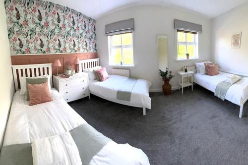 a room with three beds in a room at Olive Holiday Cottage Matlock in Matlock Bank