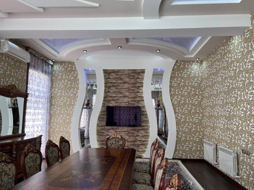 uma sala de jantar com uma mesa e uma parede de tijolos em Almotrudiy apartament em Samarkand