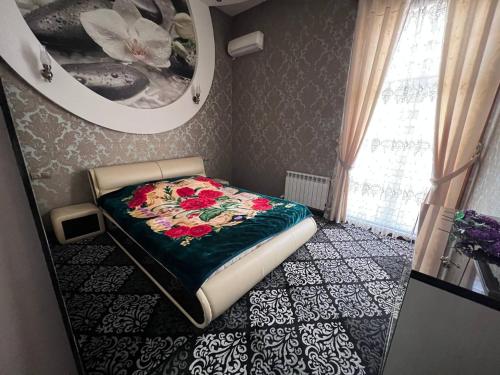 um pequeno quarto com uma cama num quarto com um espelho em Almotrudiy apartament em Samarkand