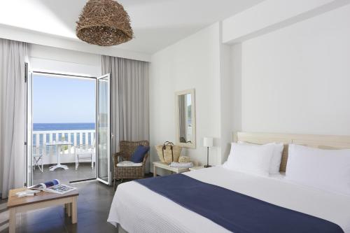 a bedroom with a bed and a view of the ocean at Artina Nuovo in Marathopolis