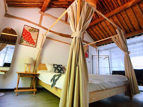 a bedroom with a canopy bed with a wooden ceiling at 隐谷私院The Great Wall Valley in Gubeikou
