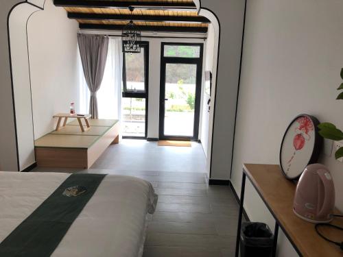a bedroom with a bed and a room with a window at 隐谷私院The Great Wall Valley in Gubeikou