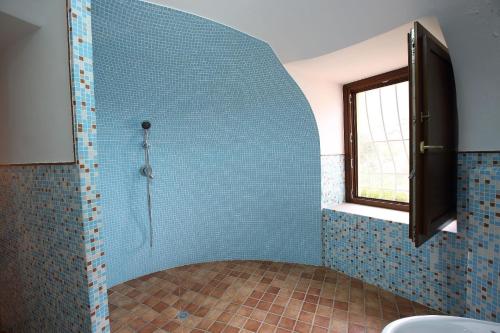 y baño con ducha de azulejos azules. en Ferienwohnung für 4 Personen ca 50 qm in Giungano, Kampanien Cilento, en Giungano