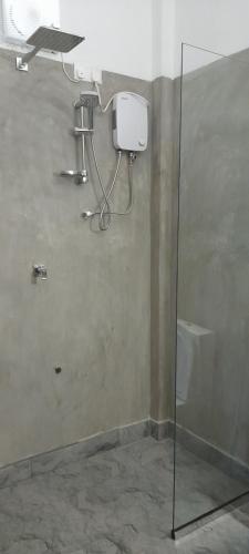 a shower in a bathroom with a glass wall at Surf Gangs Arugambay in Arugam Bay