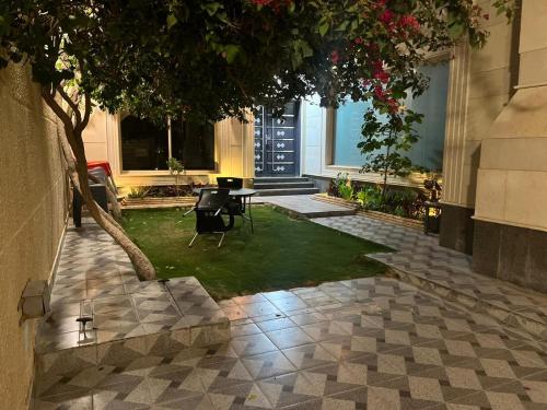 un patio con una mesa y un árbol en un edificio en سفانه en Unayzah