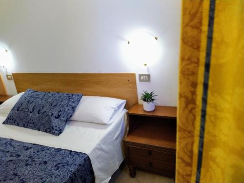 um quarto com uma cama e uma mesa com uma planta em Camere Masaccio em Certaldo