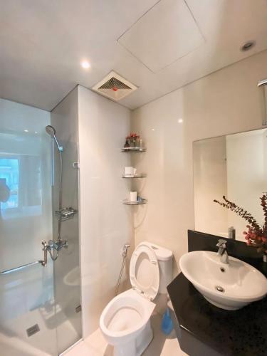 uma casa de banho com um WC, um chuveiro e um lavatório. em Palm Tree Villas - STUDIO UNIT em Manila