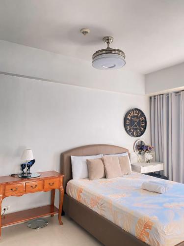 um quarto com uma cama e um relógio na parede em Palm Tree Villas - STUDIO UNIT em Manila