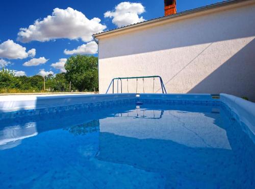 une piscine en face d'un bâtiment dans l'établissement Ferienhaus mit Privatpool für 4 Personen ca 40 qm in Pajkovići, Istrien Binnenland von Istrien, à Pajkovići
